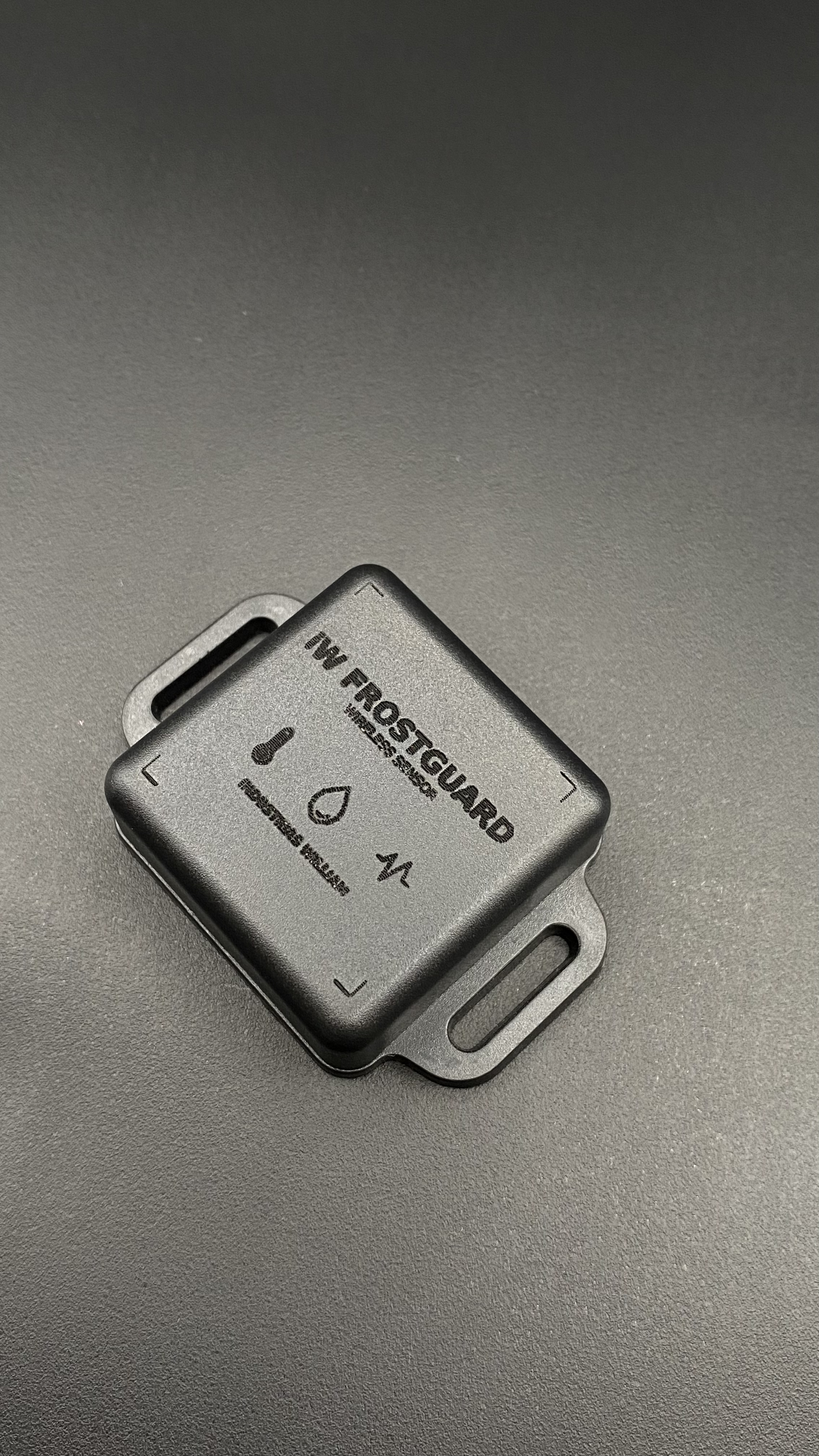 Sensor iW FrostGuard visto de perto, com os ícones de temperatura, umidade e vibração gravados na carcaça